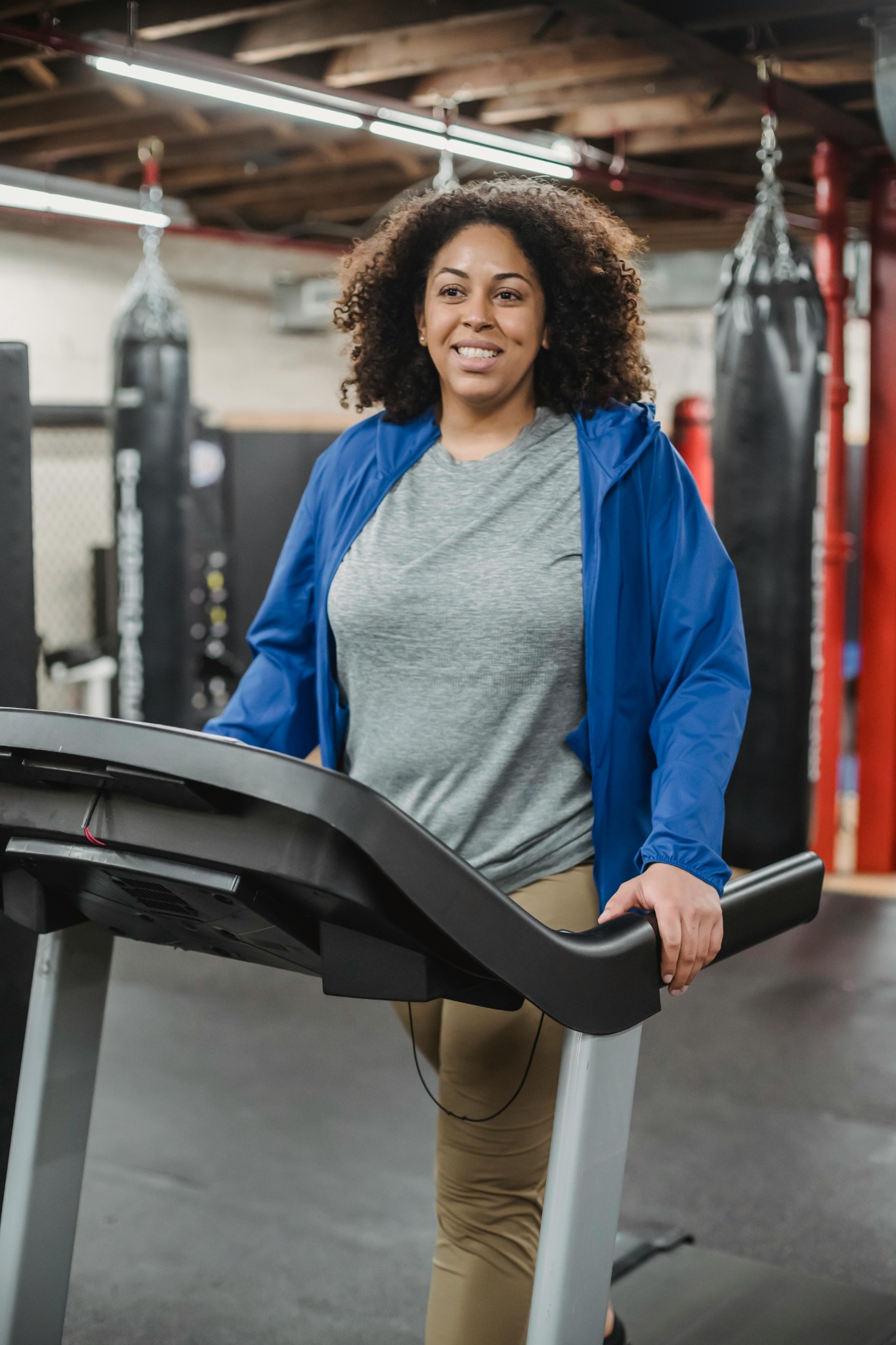 Smiling woman walking on a treadmill in a gym